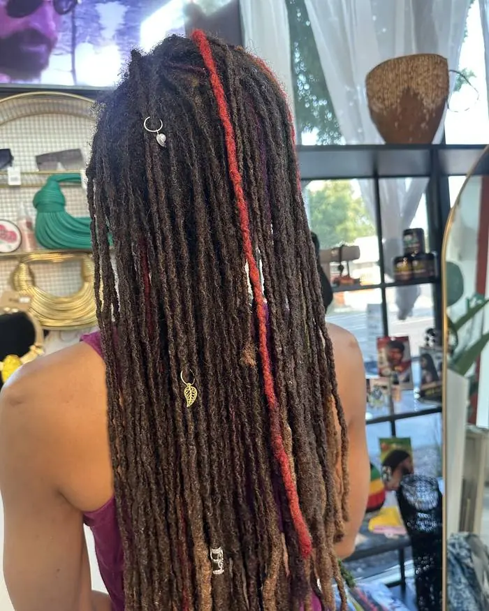Waist-length locs with red and green colour work, back view