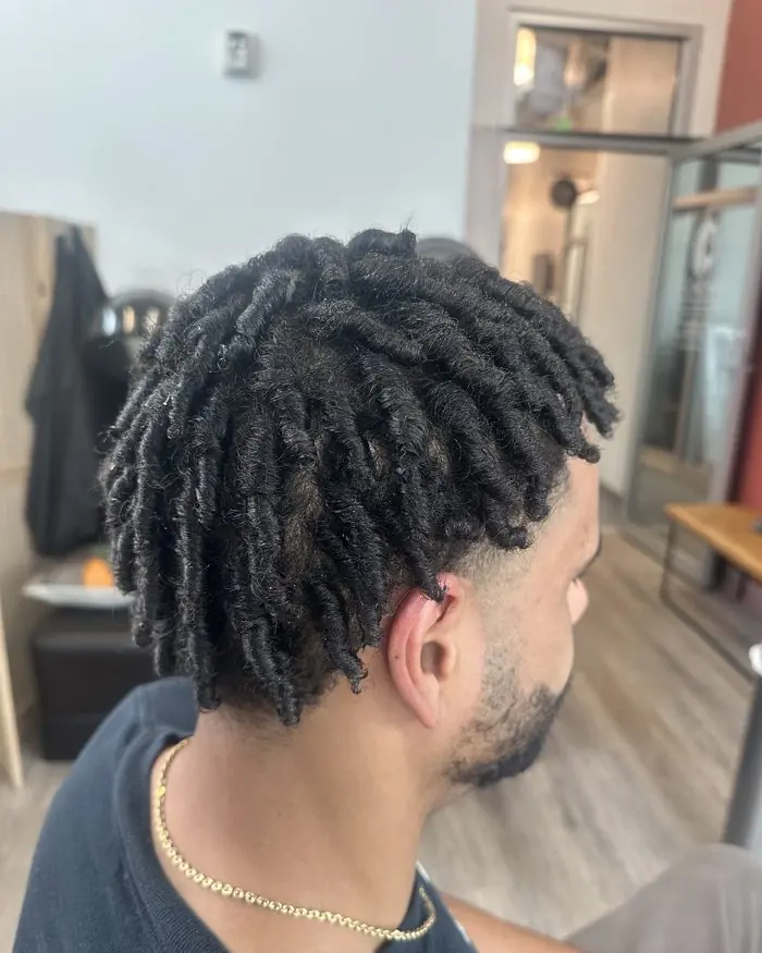 Men's short locs with a clean taper, side profile