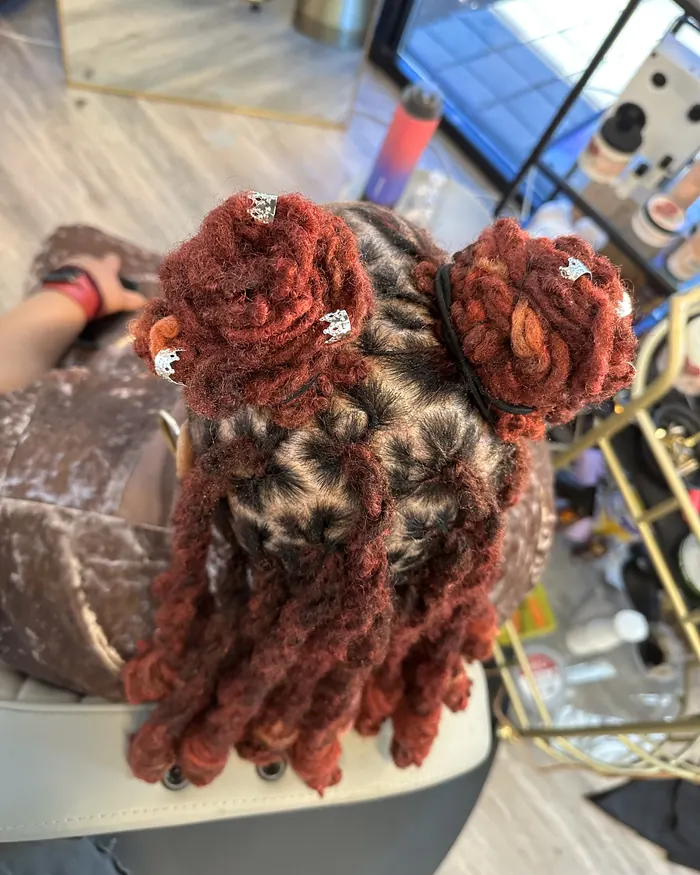 Burgundy loc knots with the curled ends falling loose
