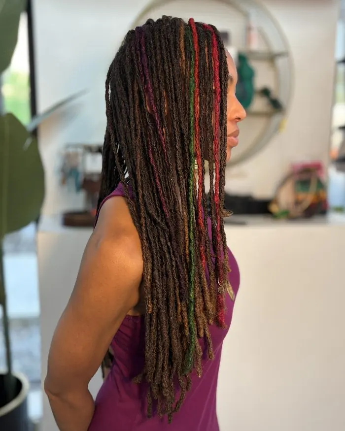 Long locs with red and green strands, side profile in the studio