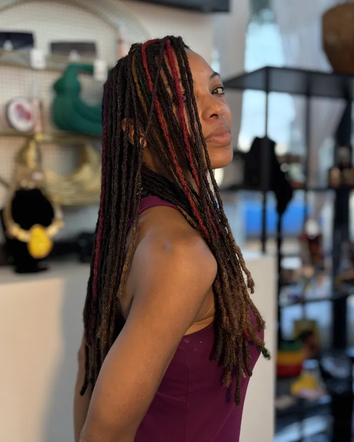 Client looking back over her shoulder, long coloured locs