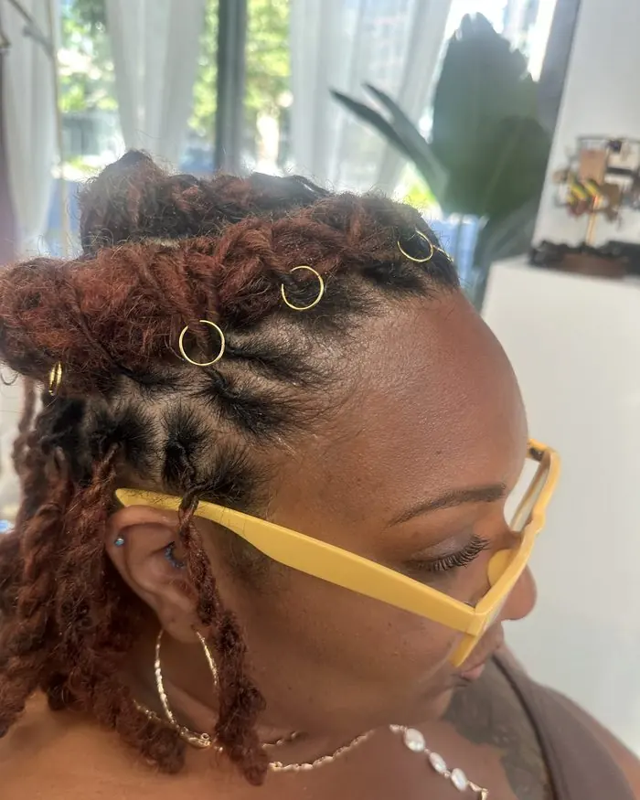 Client with copper-red locs and gold jewellery in the studio