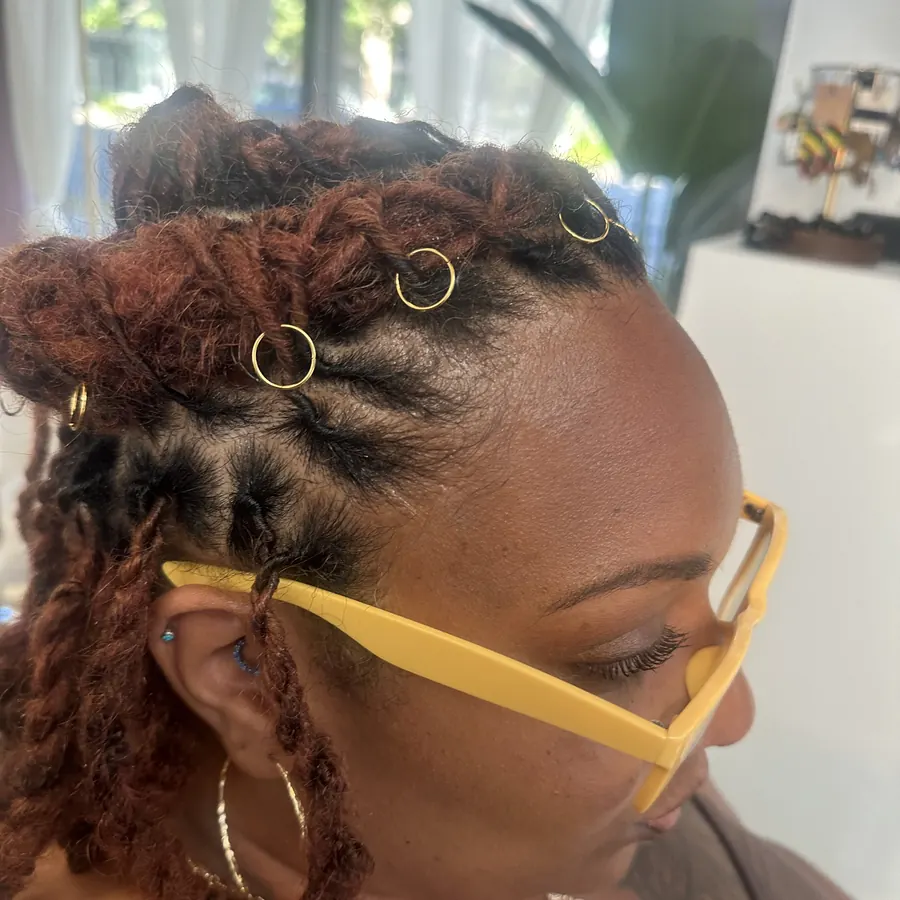 Client with copper-red locs and gold jewellery in the studio