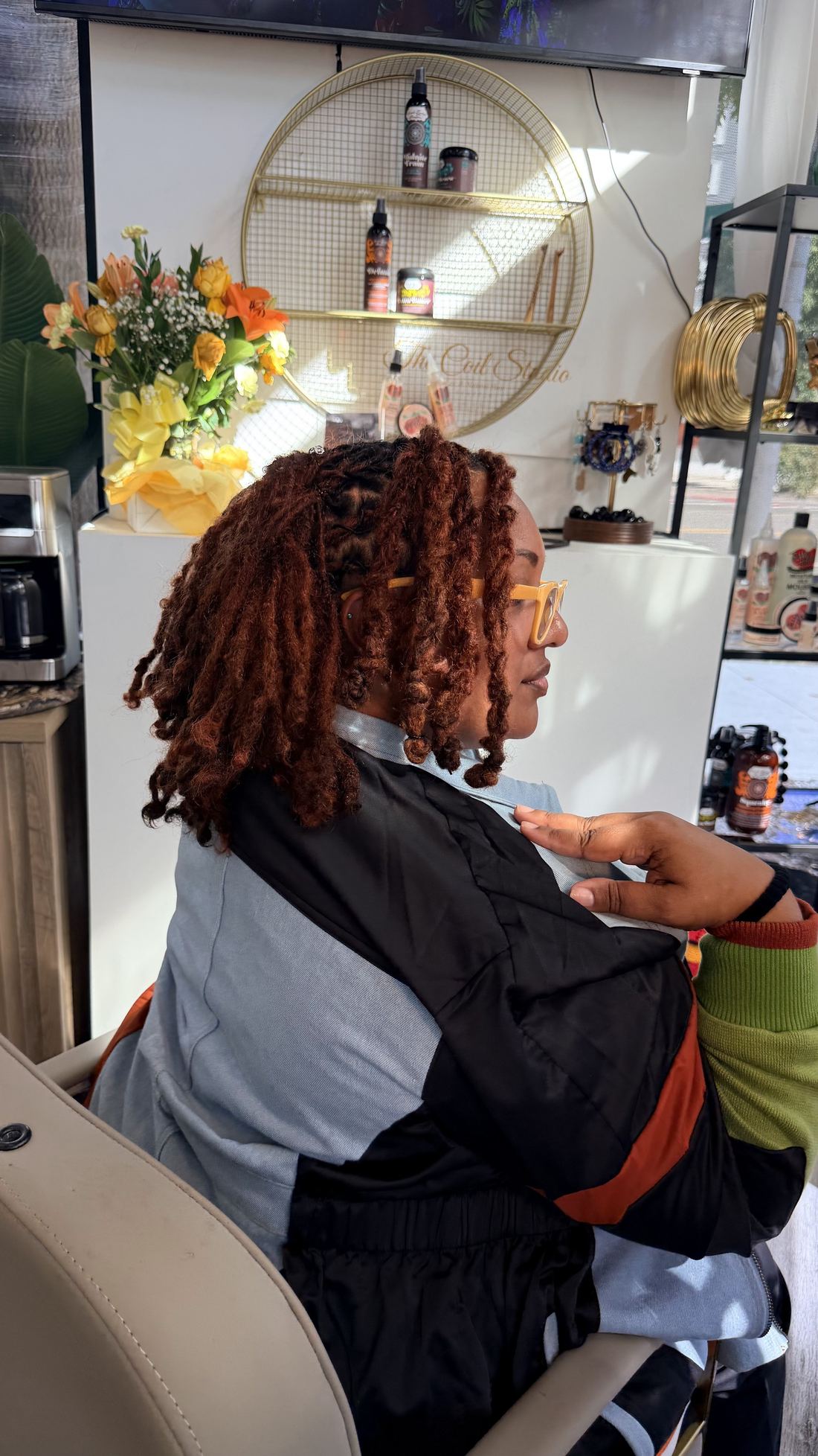 Copper-coloured locs styled in soft curls