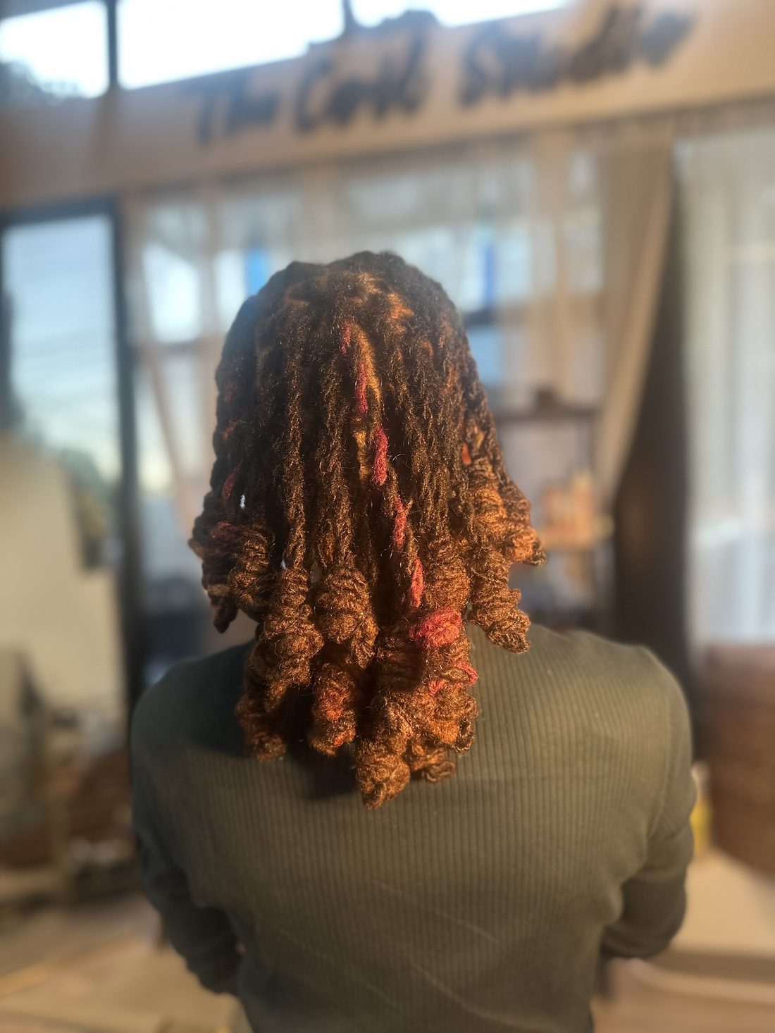 Copper locs with flame-red strands running through the curls