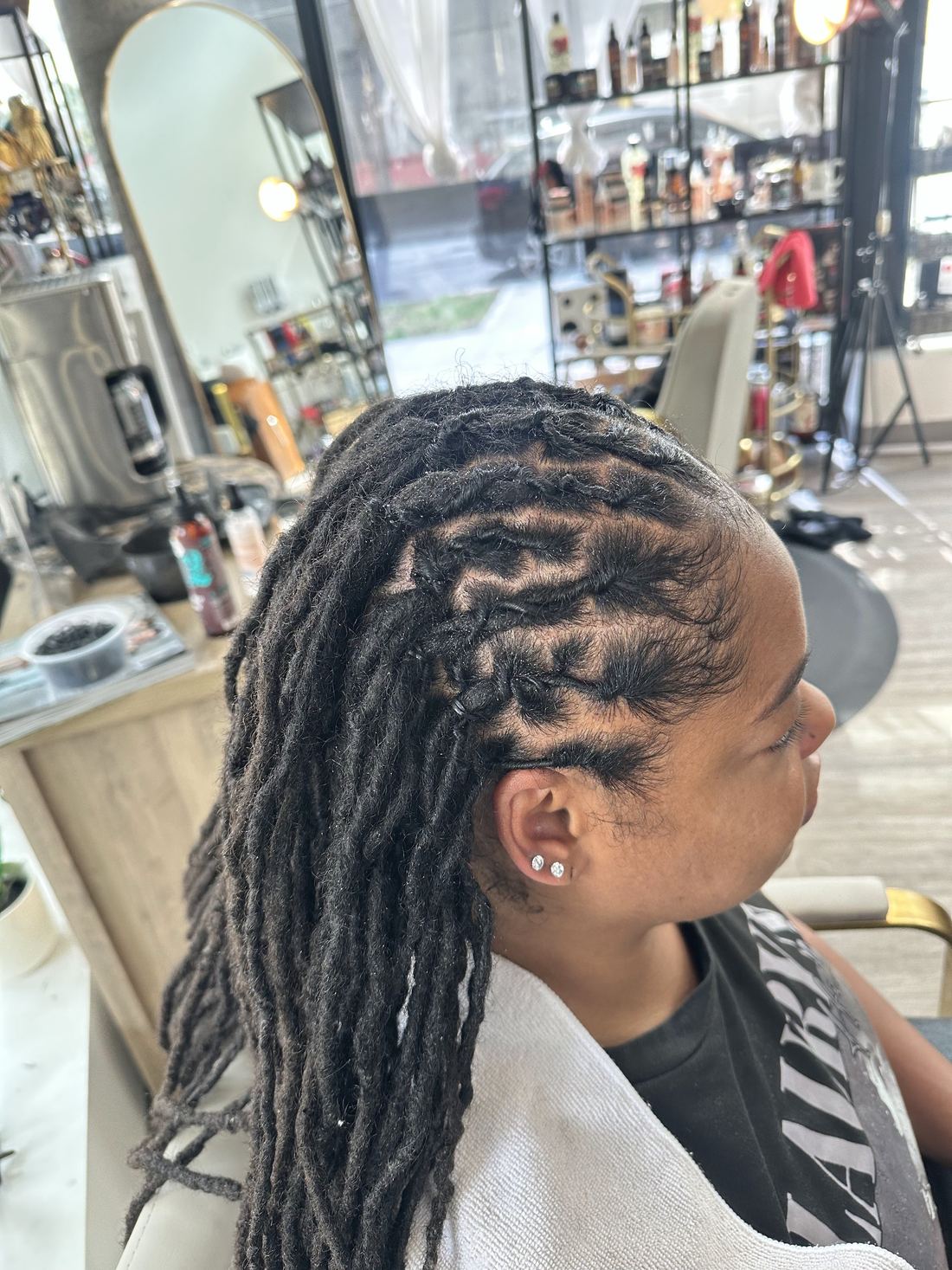 Locs retwisted with a side part and swept to one side